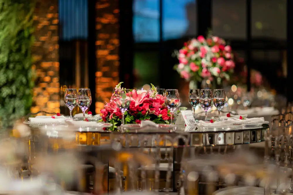 Mesa de boda elegante con diferentes platos y copas servidas por un equipo de catering